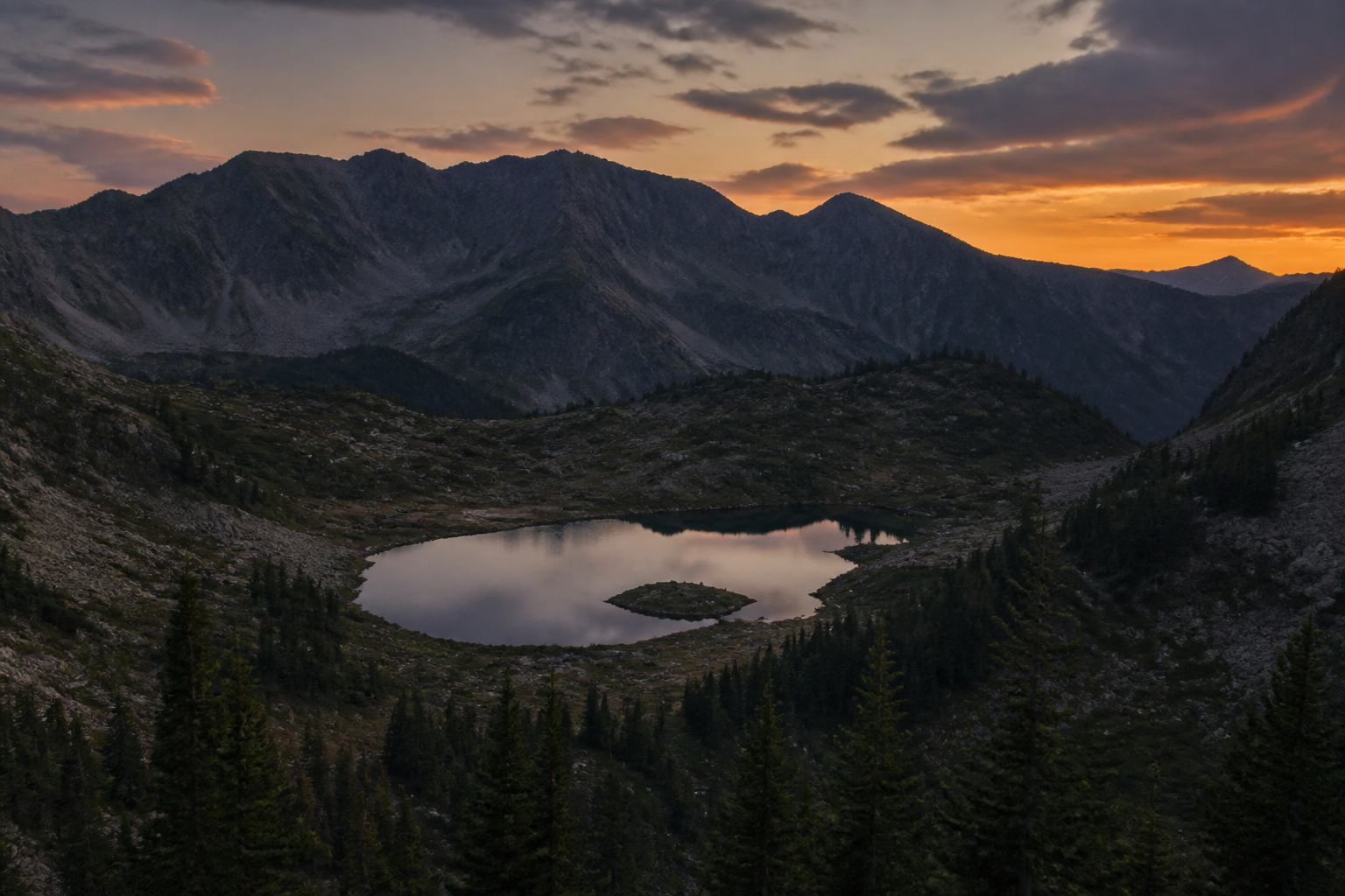 Carpathian ridge and a still lake at dusk